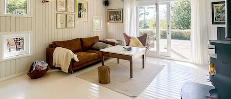 A cozy living room with a brown sofa, a wooden coffee table, and a fireplace.