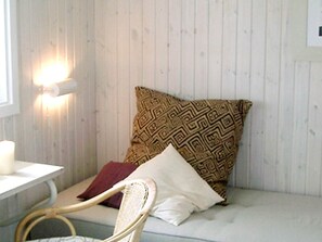 A room with a white cushioned bench, a patterned pillow, and a wall-mounted light fixture. - Splendid Holiday Home in Dronningmolle near Beach (Dronningmolle)