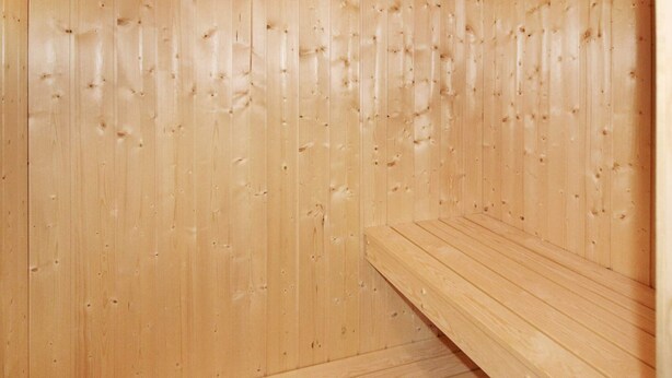 A wooden sauna with benches and a sloped floor. - Holiday Home in Wendtorf (Wendtorf)