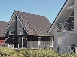 A row of modern, two-story houses with gabled roofs and large windows.