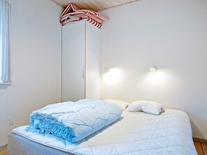 Un dormitorio con una cama, un armario y una ventana.