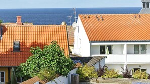 En kystbygning med tegltag, en synlig skorsten og frit udsyn til havet.