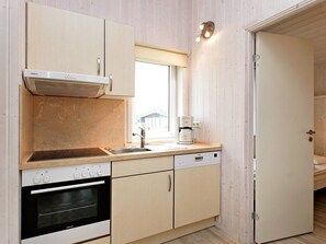 A compact kitchen with a Siemens oven, a coffee maker, and a window above the sink. - Holiday Home in GrÃ¶mmitz (Groemitz)
