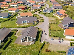 A residential area with houses, a central road, and a small building with a glass enclosure. - Holiday Home in GrÃ¶mmitz (Groemitz)