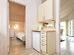 Une pièce de taille modeste comprenant un lit, une petite kitchenette et un coin repas.