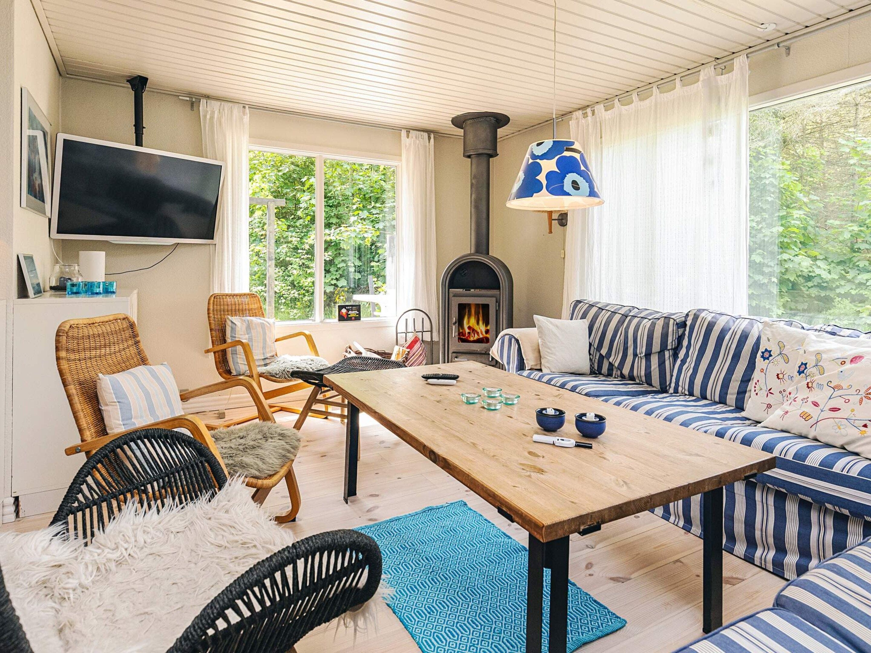 A cozy living room with a sofa, chairs, a wooden table, and a fireplace.