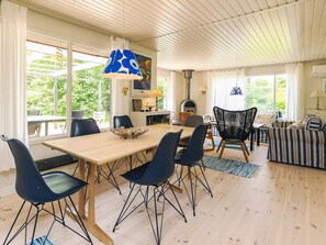 A spacious living area with a dining table, chairs, a fireplace, and a sofa.