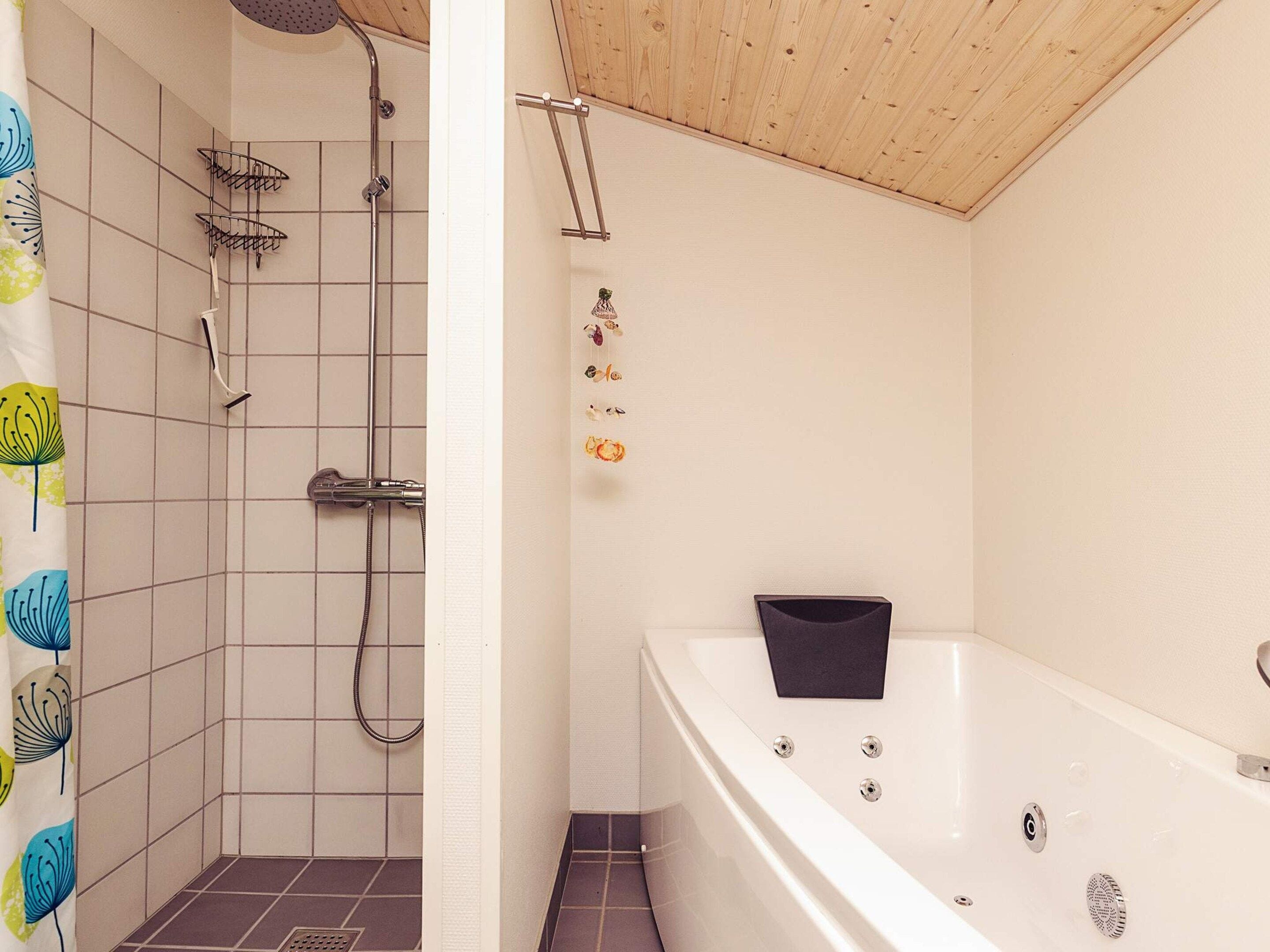 A bathroom with a shower, a bathtub, and a toilet.