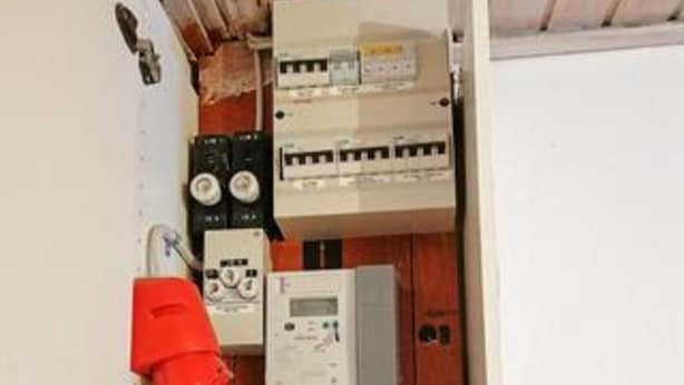 An electrical panel with circuit breakers and a control panel, indicating a utility area in a building. - 4 Star Holiday Home in Lokken (Lokken)
