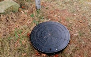 A manhole cover on grass.