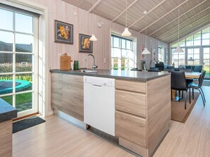 A modern kitchen with a central island, a dishwasher, and a dining area with a table and chairs. - 10 Person Holiday Home in Ansager-by Traum (Ansager)