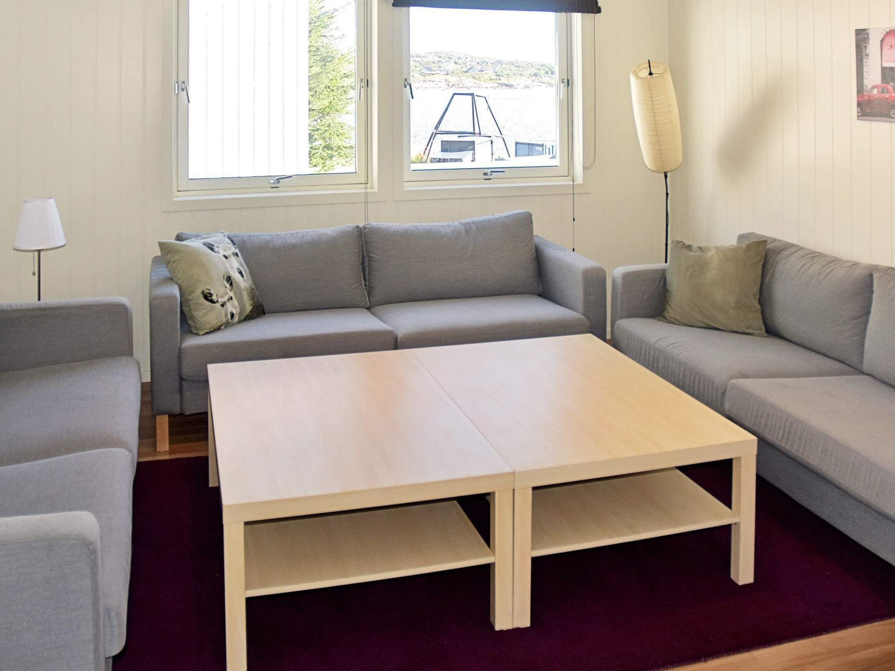 A living room with a sofa, a coffee table, and a lamp.