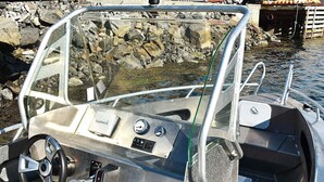 A boat's interior with a Garmin device, steering wheel, and metal railings. - 8 Person Holiday Home in Oksvoll (Orland)