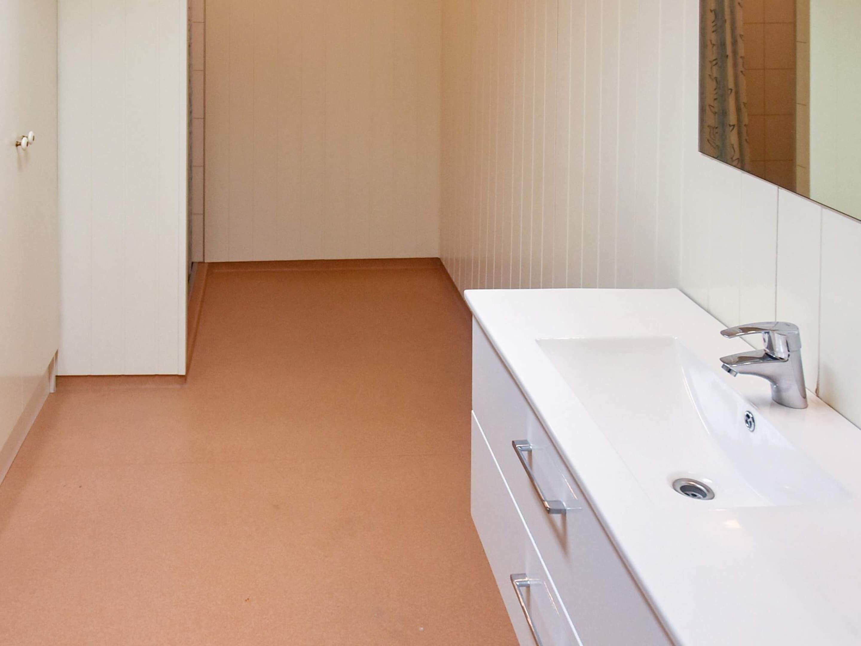 A bathroom with a white sink, a mirror, and a door.