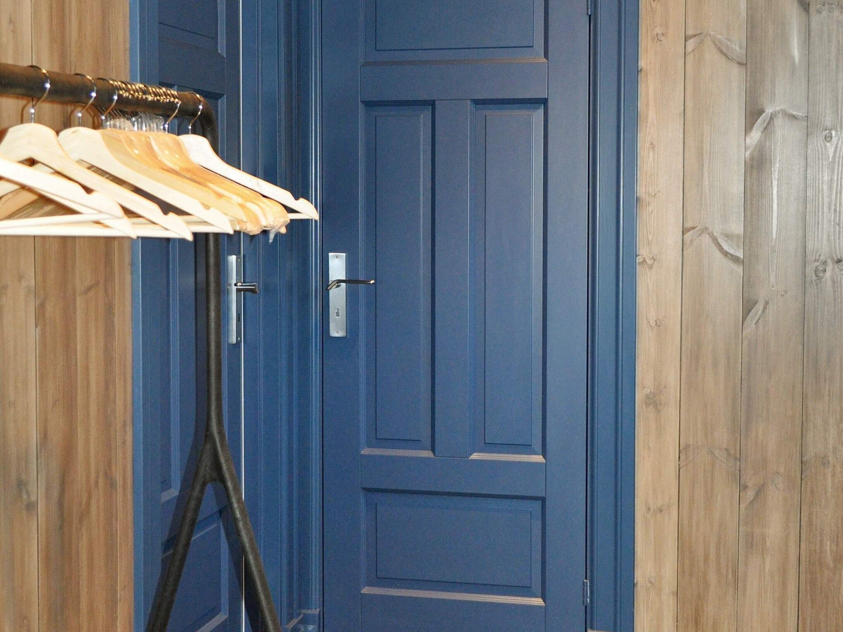 A blue door with a metal handle and a small rectangular lock plate.