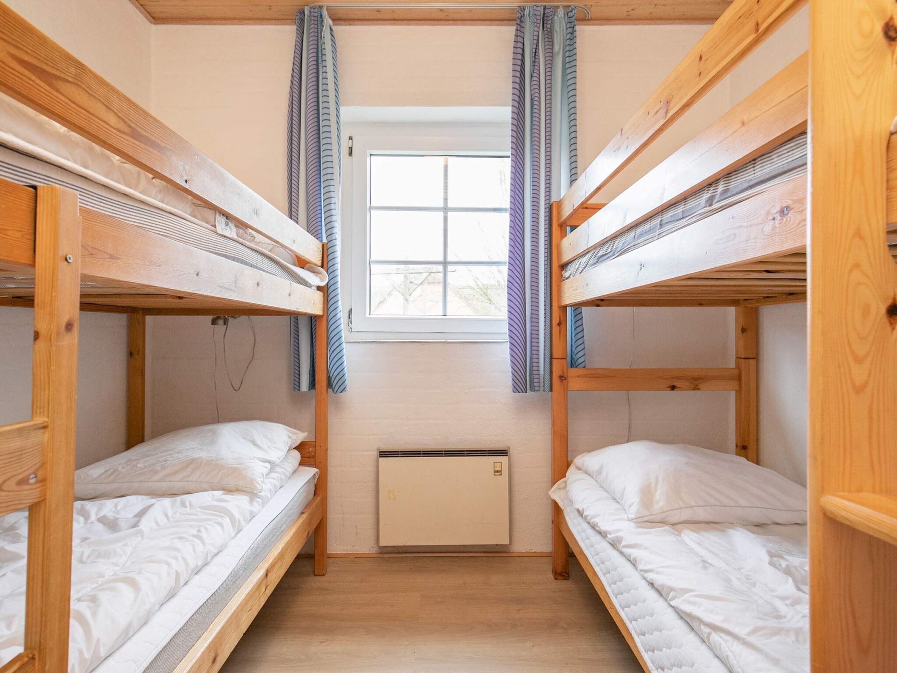 Une chambre avec un lit superposé, une fenêtre et un appareil de climatisation.