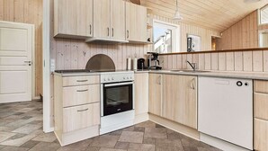 A modern kitchen with wooden cabinets, a built-in oven, and a dishwasher.