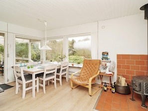 A dining area with a table, chairs, a fan, and a wood stove. - Vibrant Holiday Home in Nykobing Sj near Sea (Nykobing Sjaelland)