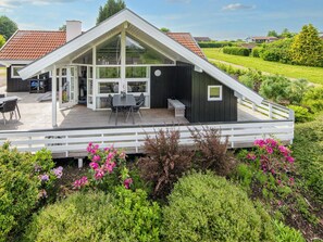 A modern house with a large deck, a dining area, and a covered patio. - Luxury Retreat With Spa - By Traum Ferienwohnungen (Hejls)