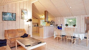 A cozy cabin interior with a living area, dining space, and kitchen.