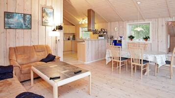 A cozy cabin interior with a living area, dining space, and kitchen.