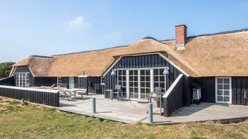 A building with thatched roofs and a wooden deck.