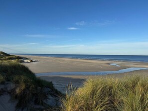 A beach with sand dunes and a clear sky.
