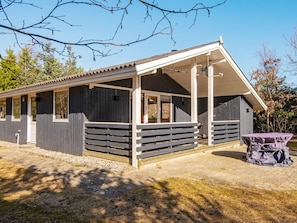 A small, single-story building with a covered porch and a fenced outdoor area. - 4 Person Holiday Home in Ulfborg (Ulfborg)