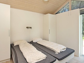 A room with two single beds, a wooden ceiling, and a window with a view of greenery. - 5 Star Holiday Home in Albaek (Aalbaek)