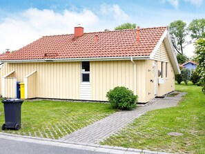 A single-story house with a red-tiled roof, a small front porch, and a paved driveway. - Holiday Home in Otterndorf (Otterndorf)