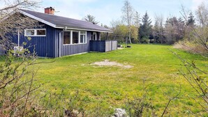 A house with a fenced yard and a swing set. - Secluded Holiday Home in Jutland near Beach (Hals)