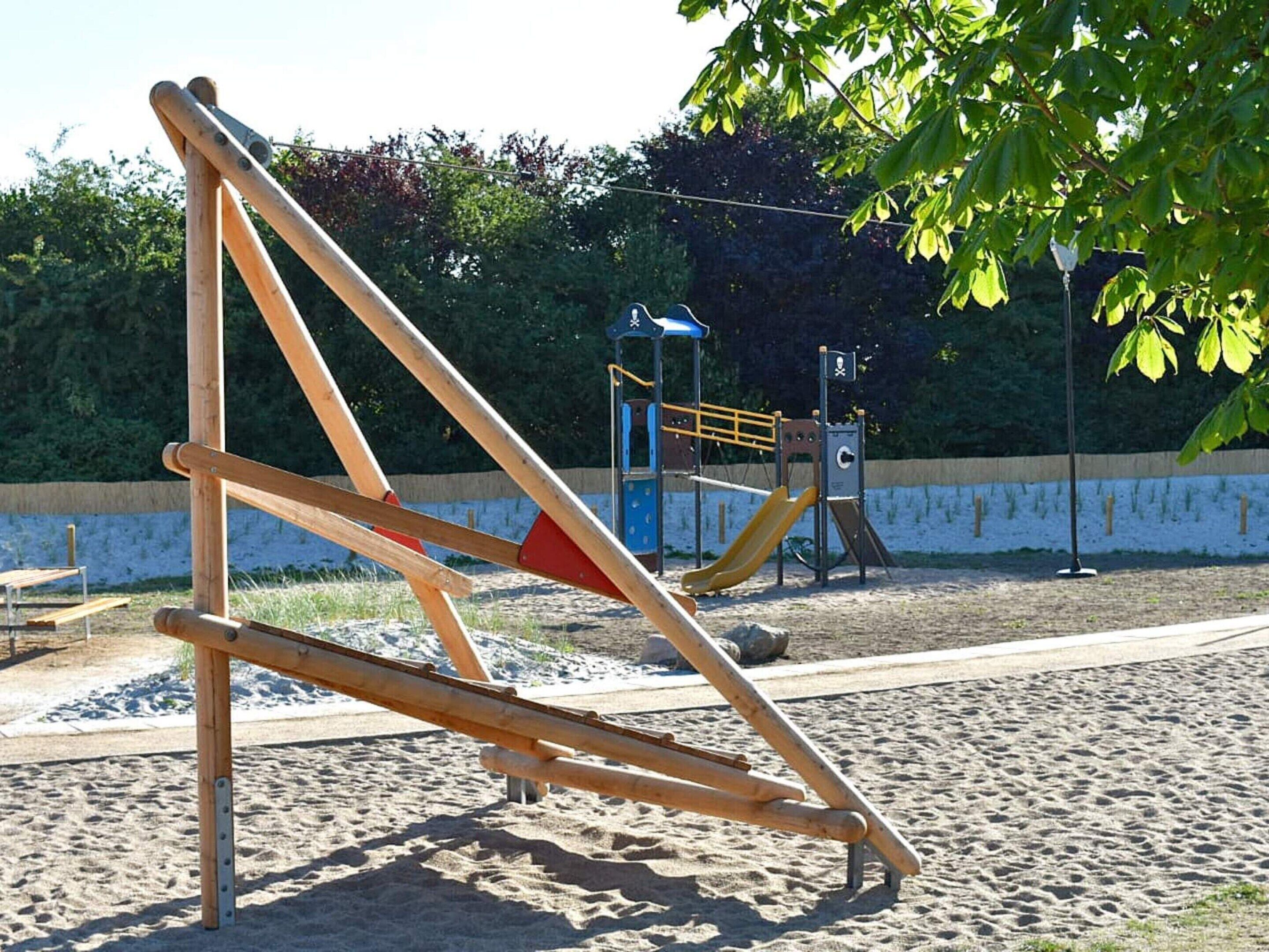 Un parque infantil con sube y baja, tobogán y estructura para escalar.