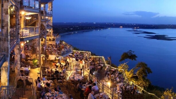 Un restaurante frente al agua con terraza al aire libre y vista al mar.