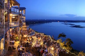 A waterfront restaurant with outdoor seating overlooking a body of water. - NEW! AUSTIN HILL COUNTRY CHARM! POOL/HOT TUB/VIEWS (Dripping Springs)