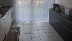 Eine Küche mit großem Fenster, einer Uhr und einer Kücheninsel.