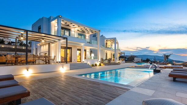 Uma villa moderna com piscina, área de estar externa e vista para as montanhas.