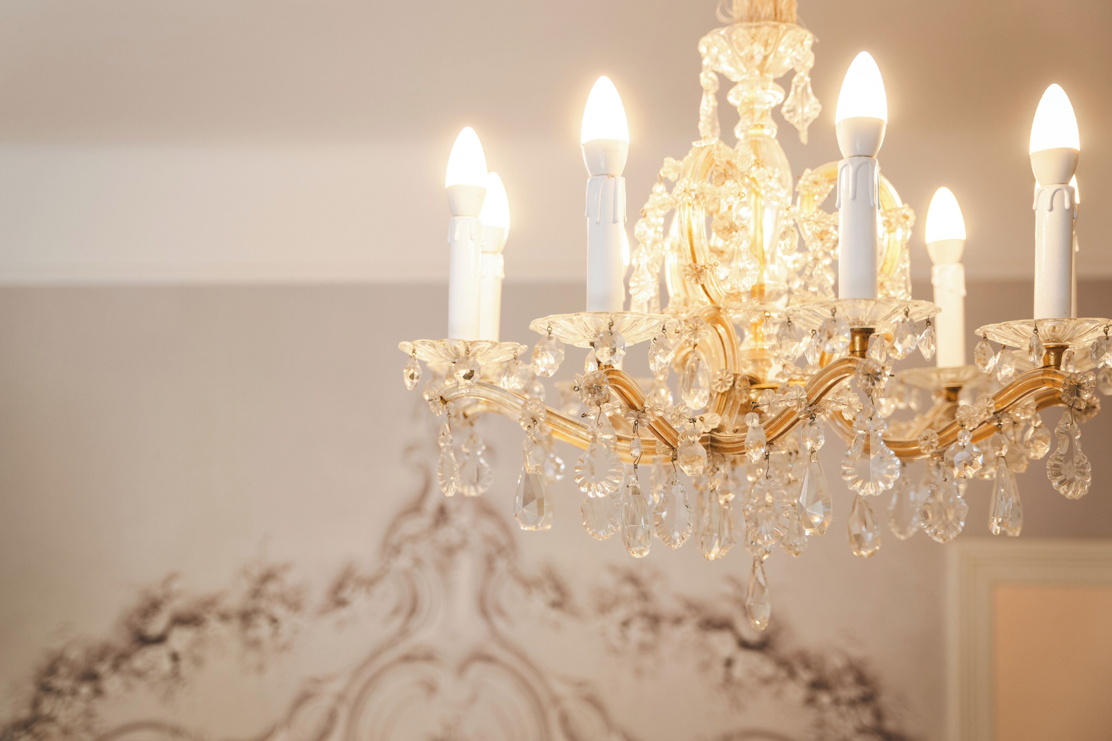 A chandelier with multiple candle-like lights and crystal decorations.
