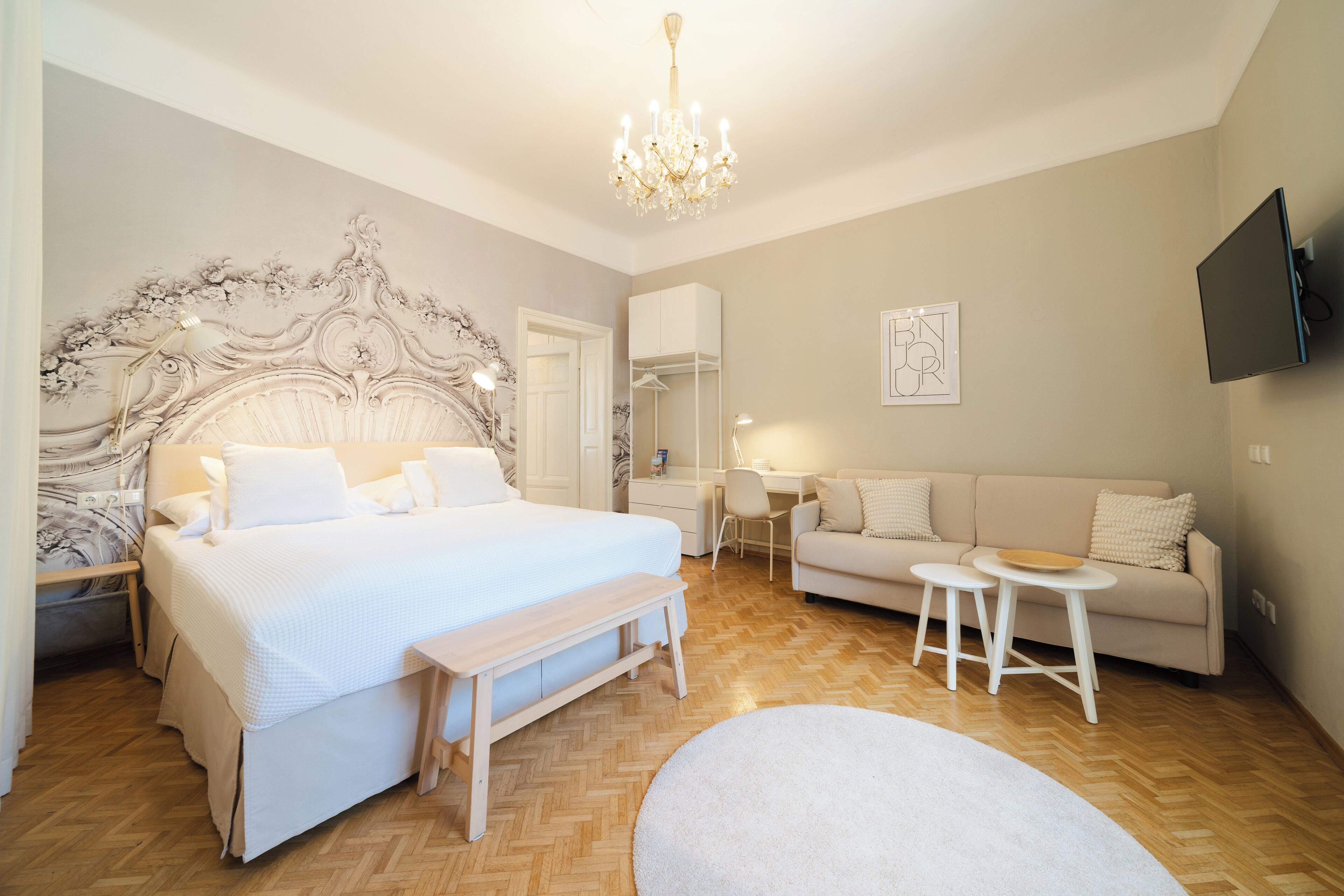 Ein Schlafzimmer mit einem großen Bett, einem Schreibtisch, einer Couch und einem Fernseher.