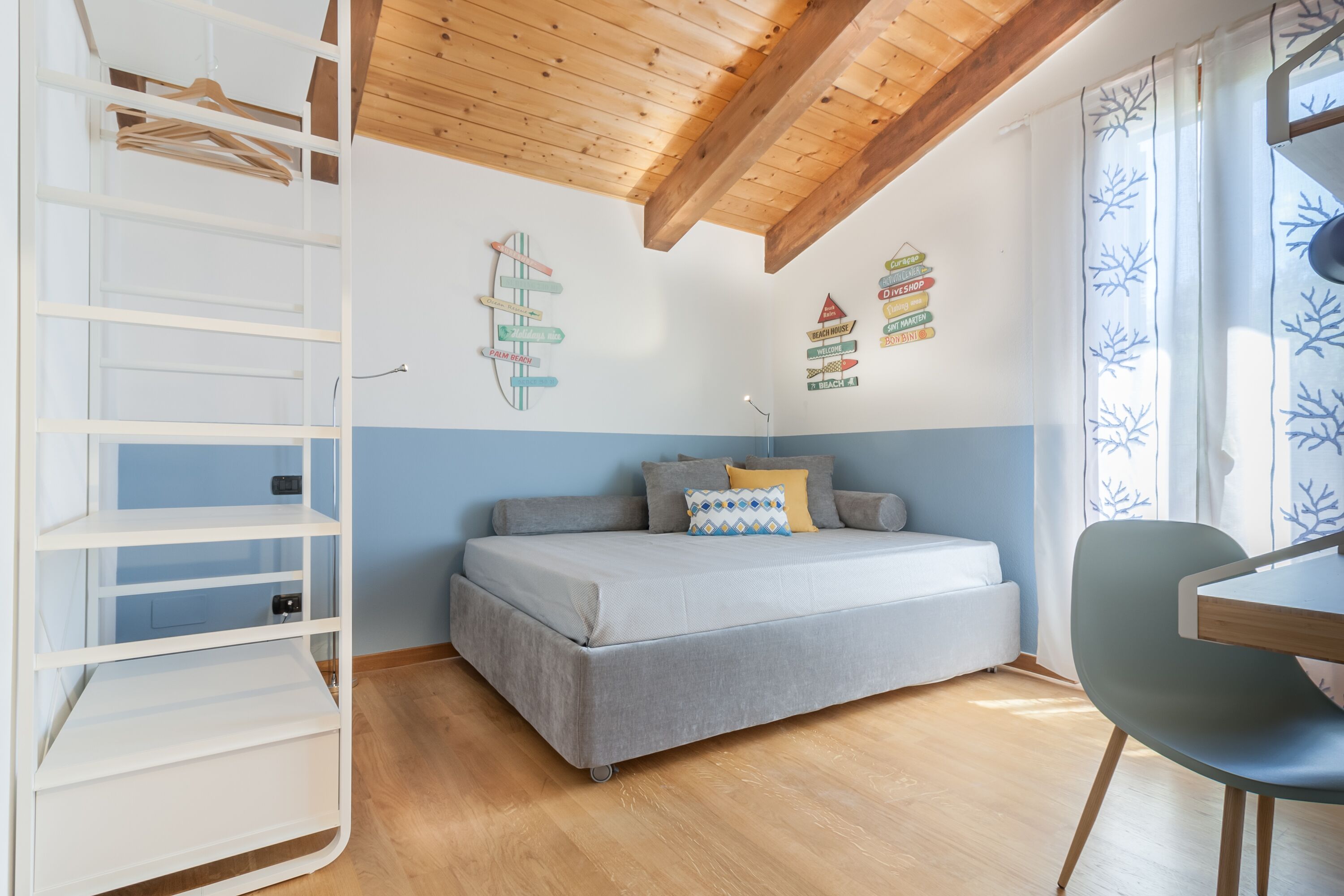 Ein Schlafzimmer mit Bett, Schreibtisch, Stuhl, Kleiderschrank und Wanddekorationen.