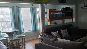 A living room with a grey sofa, a wooden coffee table, and a bunk bed in the background. - Coastal Sands located @ Gulf Terrace Condos in Destin! Sleeps 6 ~ 1BR & 1-1/2 BA (Destin)