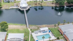 A hotel with a dock extending into a lake, a swimming pool, and a parking lot. - Coastal Sands located @ Gulf Terrace Condos in Destin! Sleeps 6 ~ 1BR & 1-1/2 BA (Destin)