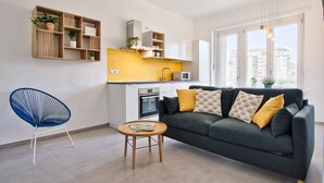 A modern living room with a grey sofa, a blue chair, and a wooden coffee table. - Urban House Carducci - Apartments (Turin)