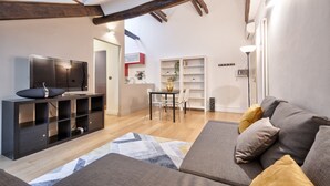 Ein modernes Wohnzimmer mit Sofa, Fernseher und Einbauschränken.
