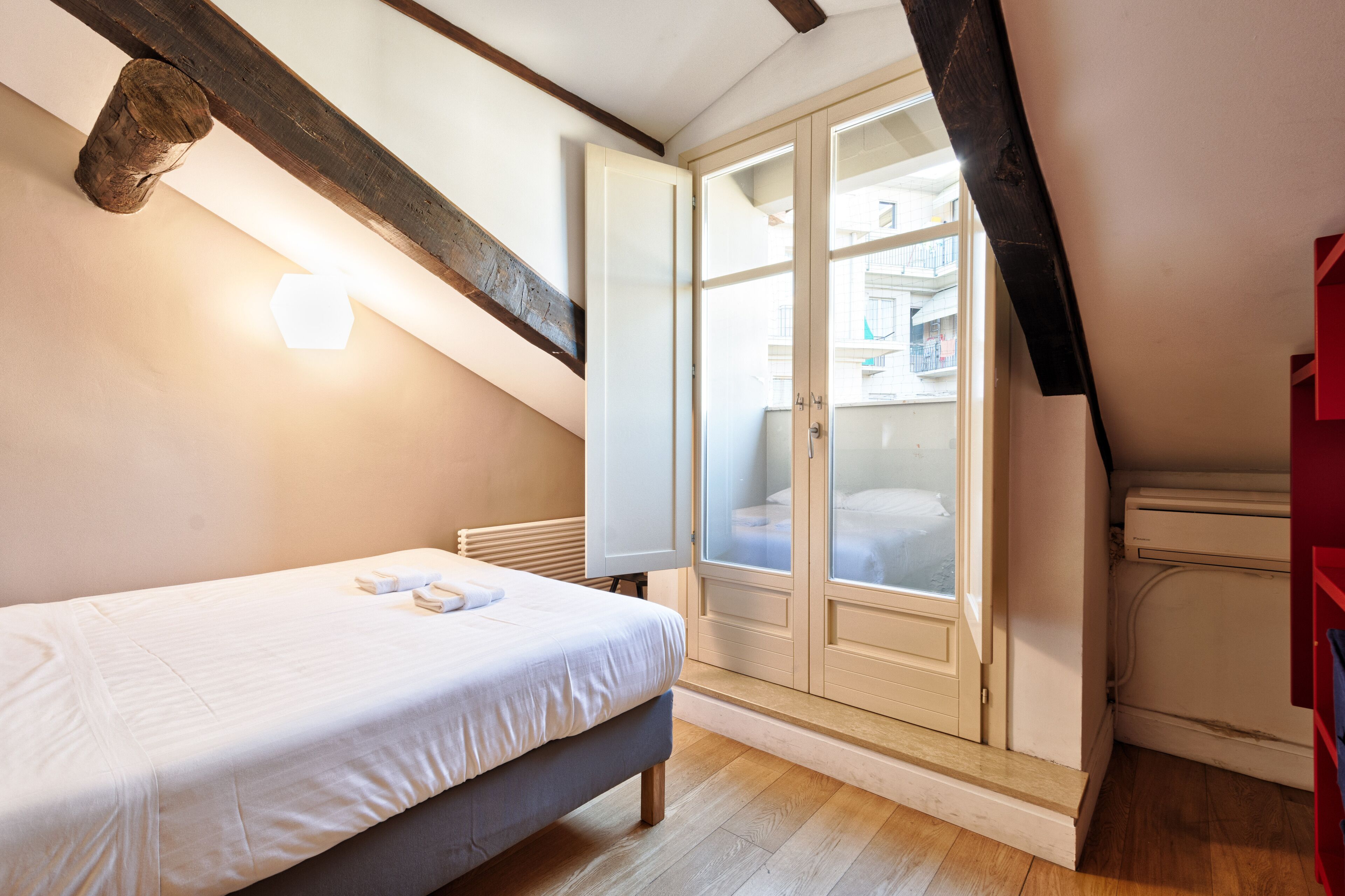 A bedroom with a bed, a wardrobe, and a window.