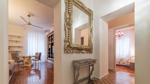 Un salón espacioso con un comedor, un espejo grande y ornamentado, y un suelo a cuadros.