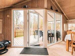 A wooden interior with a sliding glass door leading to an outdoor deck.