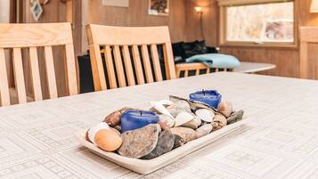 A wooden interior with a table set with stones and candles.