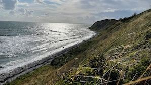 Un paysage côtier caractérisé par une côte rocheuse et des falaises herbeuses.