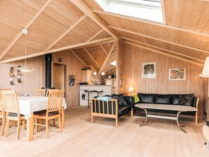 Een houten interieur met een eethoek, een bank en een keuken.