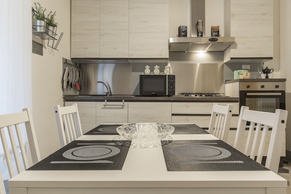 A modern kitchen with a dining table, chairs, and a central island.